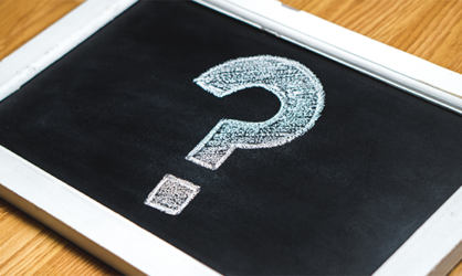 Question mark drawn in white chalk on a rectangular chalkboard with a white frame.