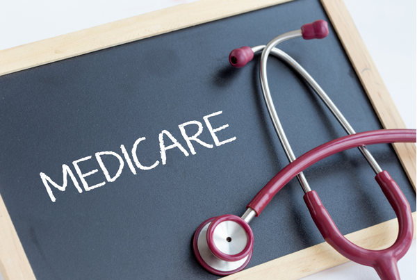 Medicare written on Chalkboard in white chalk with a red stethoscope resting on top of the chalkboard on the right side