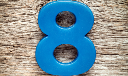 Blue plastic number 8 on a light wood background