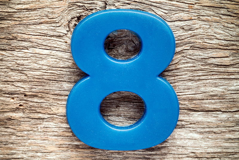 Blue plastic number 8 on a light wood background